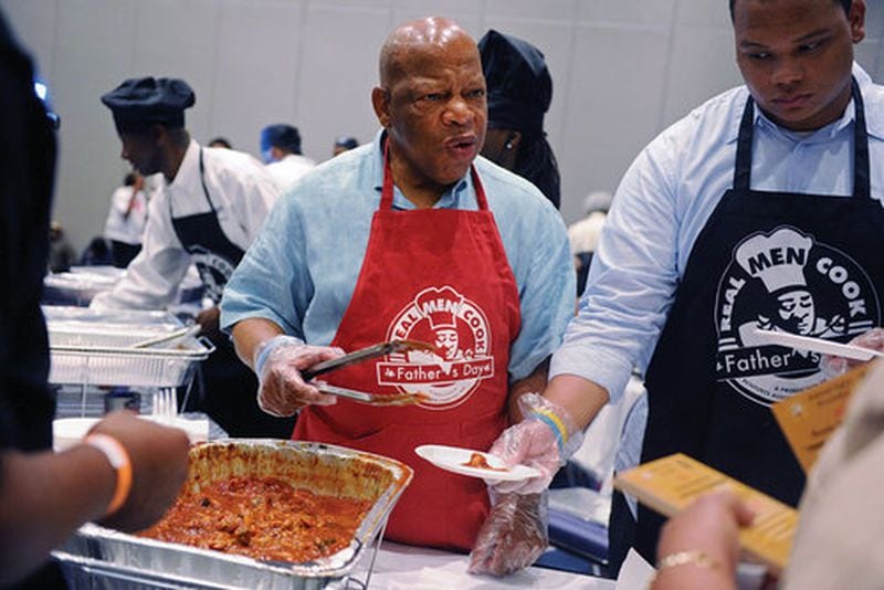 Rep. John Lewis (center) serves the barbecued chicken he prepared at the Real Men Cook event in 2012. The event is now known as the Family Food Fest.