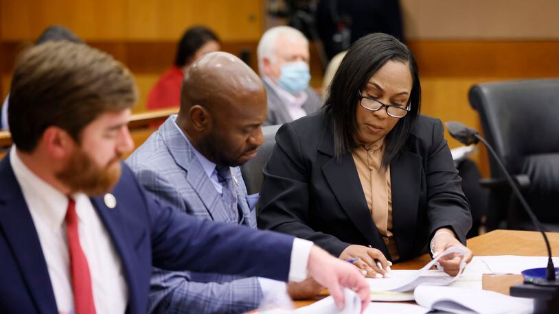 Fulton County D.A. Fani Willis (right) interacts with colleagues during a hearing where they suggest that Fulton County Superior Judge Robert McBurney not release the results of an eight-month-long investigation by a special grand jury to the public. Miguel Martinez / miguel.martinezjimenez@ajc.com