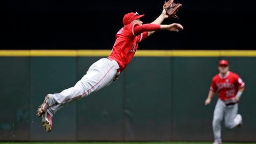 Los Angeles Angels shortstop Andrelton Simmons stretches as he snags a line drive by Seattle Mariners' Jean Segura in the first inning of a baseball game Sunday, Aug. 13, 2017, in Seattle. (AP Photo/Elaine Thompson)