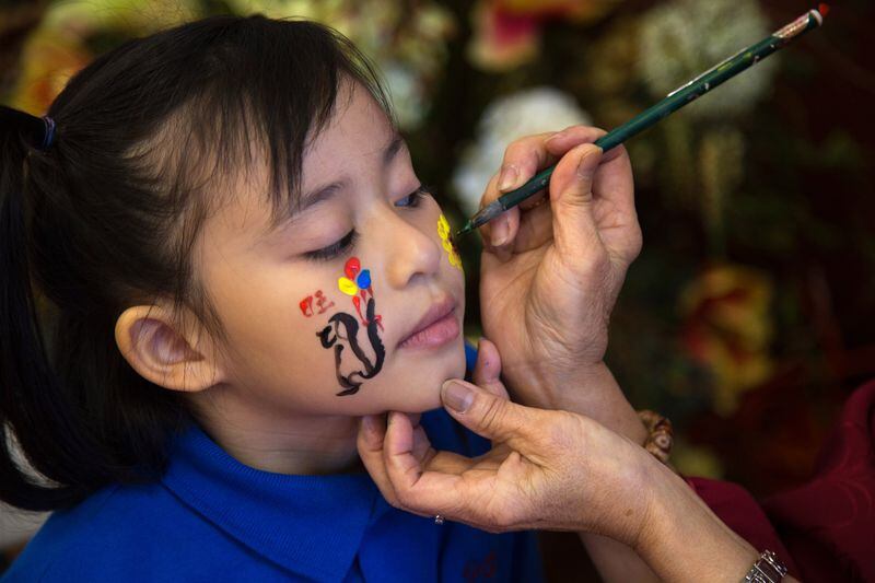 Synclaire Hernandez gets a dog painted on her face during the 2018 Atlanta Chinese Lunar New Year Festival in Chamblee, Ga., on Sunday, Feb. 18, 2018. 