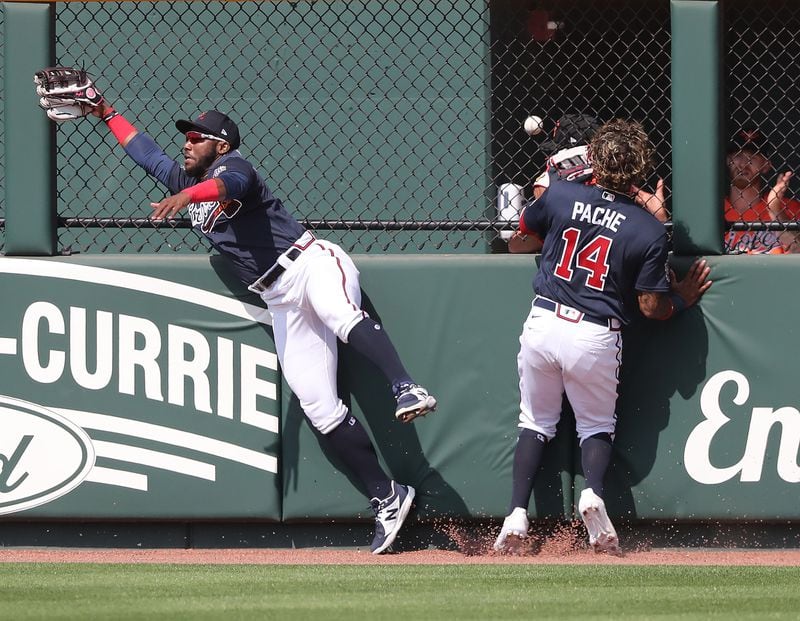The ball goes over the fence and into the Baltimore Orioles' bullpen as Atlanta Braves outfielders Michael Harris (left) and Cristian Pache make a futile effort the wall for Austin Hays two-run homer in the fifth inning Wednesday, March 3, 2021, at CoolToday Park in North Port, Fla. (Curtis Compton / Curtis.Compton@ajc.com)