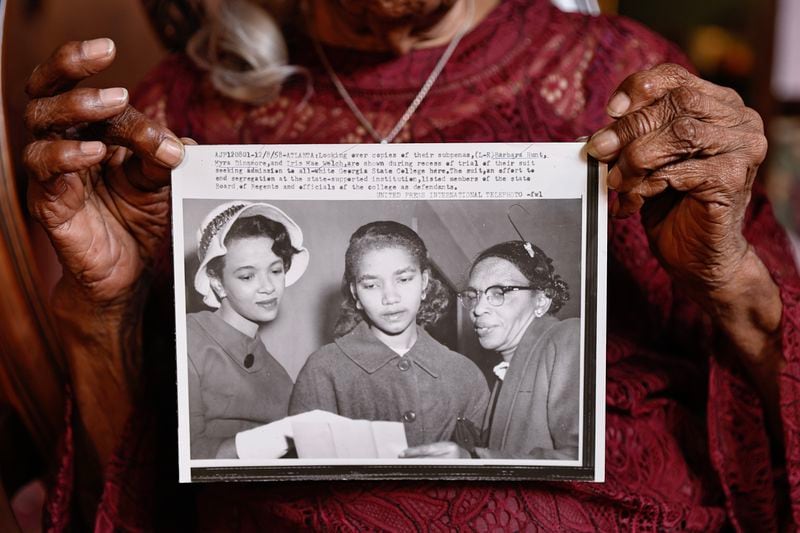 Myra Elliott holds a 1958 photo of herself (center) along with Barbara Hunt (left) and Iris Mae Welch (right) on Thursday, Dec. 8, 2022. They sued to desegregate Georgia State University in 1956. (Natrice Miller/natrice.miller@ajc.com)