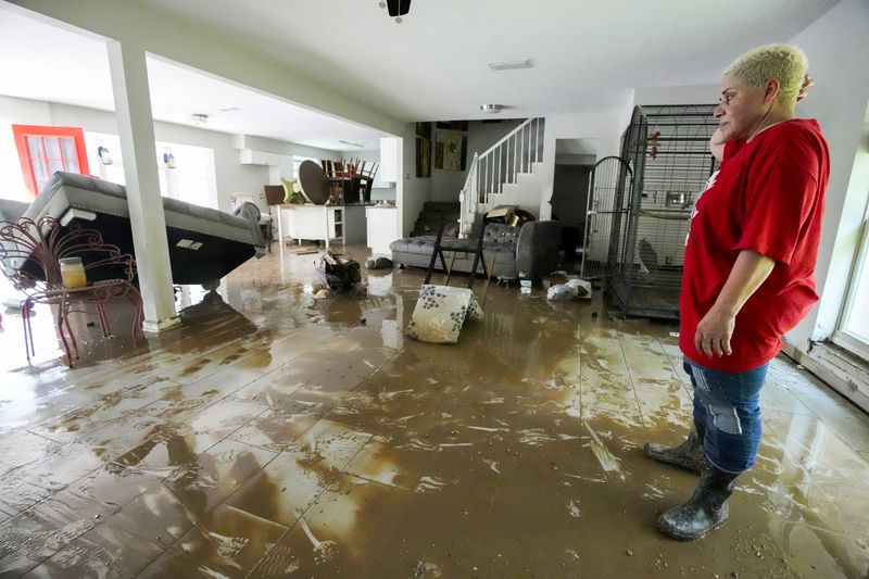 Yanira Diaz stands in her muddy living room as she begins the clean up process of her flood-damaged home in the River Plantation neighborhood on Monday, May 6, 2024, in Conroe, Texas. (Brett Coomer/Houston Chronicle via AP)