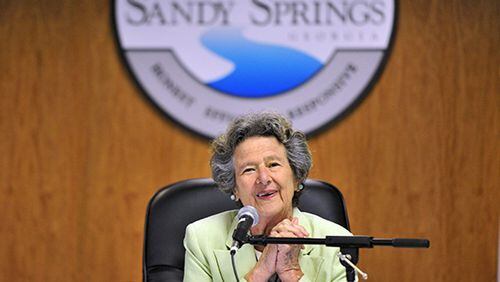 The late Sandy Springs Mayor Eva Galambos led the ceremonial “first bite” with a grapple craw in 2013 to begin the City Springs downtown redevelopment. Soil collected from around the community will be used for landscaping along a City Springs street named in her honor, Galambos Way. AJC FILE