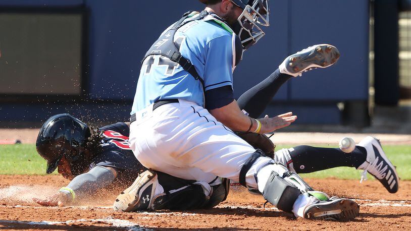 Atlanta Braves outfielder Justin Dean touches home plate past the tag of Tampa Bay Rays catcher Kevan Smith during the fourth inning of the spring training opening game Sunday, Feb. 28, 2021, at Charlotte Sports Park in Port Charlotte, Fla. (Curtis Compton / Curtis.Compton@ajc.com)