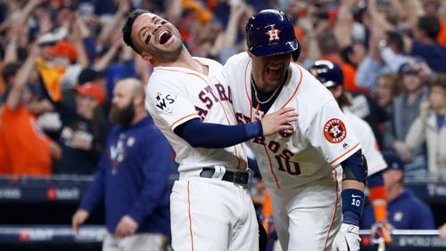 Jose Altuve #27 and Yuli Gurriel #10 of the Houston Astros celebrate after a two-run home run by Carlos Correa in game five of the 2017 World Series against the Los Angeles Dodgers.