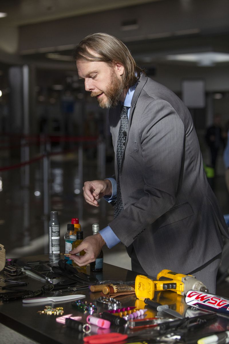 Mark Howell, regional spokesperson for TSA, shows reporters items confiscated by the TSA in the Hartsfield-Jackson international airport on Monday, December 12, 2022. AAA predicts a busy travel season during the holidays. CHRISTINA MATACOTTA FOR THE ATLANTA JOURNAL-CONSTITUTION