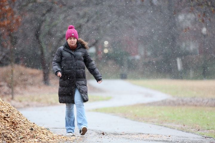 A person takes a walk as light snow falls in Piedmont Park on Sunday, Jan. 16th, 2022, in Atlanta. Miguel Martinez for The Atlanta Journal-Constitution