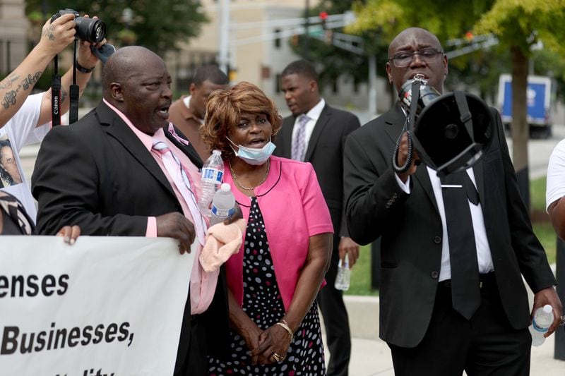 081122 Atlanta, Ga.: Attorney Ben Crump, right, speaks next to Marvin and Mary Grier during a gathering to demand action for the late Brianna Grier at Liberty Plaza across the street from the State Capitol, Thursday, August 11, 2022, in Atlanta. Grier is the woman who died after Hancock Police officers left the door open on the back of the police car after arresting her. Brianna was Marvin and Mary’s daughter. (Jason Getz / Jason.Getz@ajc.com)