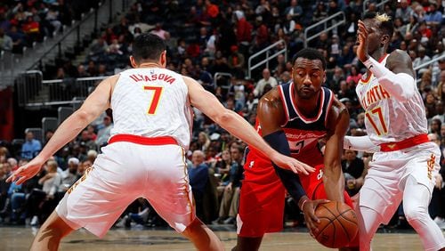 John Wall of the Washington Wizards drives between Ersan Ilyasova (7) and Dennis Schroder (17) of the Atlanta Hawks at Philips Arena on December 27, 2017 in Atlanta, Georgia.    (Photo by Kevin C. Cox/Getty Images)