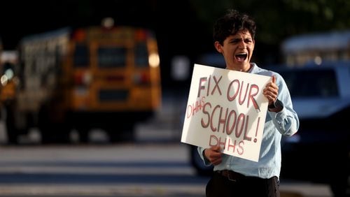 041822 Stone Mountain: Druid Hills sophomore Santiago Gonzalez-Cassavoy holds a sign reading, “Fix Our School!,” showing support of school renovations outside of the DeKalb County School System Administrative and Instructional Complex during a DeKalb County Board of Education meeting Monday, April 18, 2022, in Stone Mountain, Ga. (Jason Getz / Jason.Getz@ajc.com)