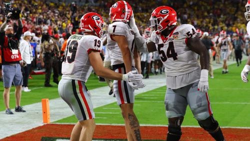 Georgia Bulldogs offensive lineman Justin Shaffer (54) celebrates with Georgia Bulldogs wide receiver Jermaine Burton (7) and  Georgia Bulldogs tight end Brock Bowers (19) after Burton completed a 57 yard pass ahead of Michigan Wolverines defensive back Vincent Gray (4) for  a touchdown in the 2nd quarter of the 2021 College Football Playoff Semifinal between the Georgia Bulldogs and the Michigan Wolverines at the Orange Bowl at Hard Rock Stadium in Miami Gardens. Curtis Compton / Curtis.Compton@ajc.com