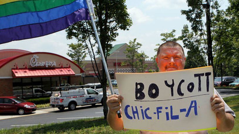 August 1, 2012 - Lone protestor Dwayne Tatum marches in front of fans as they jam the Chick-fil-A in Sandy Springs on Mount Vernon Highway on Wednesday August 1st, 2012 to show their support for company president Dan Cathy's stand on gay marriage. Chick-fil-A Appreciation Day is the brainchild of former Arkansas governor and presidential candidate Mike Huckabee. Cathy told an online Christian news outlet in mid-July that he is "guilty as charged" for supporting marriage as traditionally defined. Huckabee says the ensuing firestorm over that remark, including calls for boycotts and blocking Chick-fil-A stores in two cities, shows intolerance for folks with a different view than supporters of gay marriage and he wants to show the company it has support.