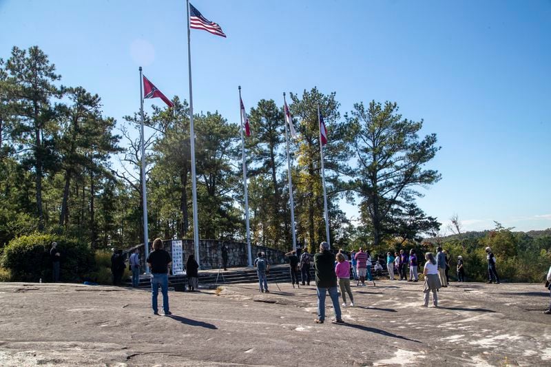 10/6/2020 - Stone Mountain, Georgia - Individuals stand at a distance from one another while participating in a Stone Mountain Action Coalition Òprayer for our parkÓ event at the flag terrace at the Stone Mountain walk-up trail in Stone Mountain, Tuesday, October 6, 2020. Faith leaders gathered and prayed for peace, compassion, healing, integrity, endurance, love and understanding for hopes of bringing change to Stone Mountain Park. ÒAs the [Stone Mountain] Park continues to serve as a rally point for hate groups and violence, SMAC believes it is more important than ever to demonstrate the desperate need for peace and extraordinary opportunity it has to serve as a place of unity,Ó said a flyer give out by the Stone Mountain Action Coalition. (Alyssa Pointer / Alyssa.Pointer@ajc.com)