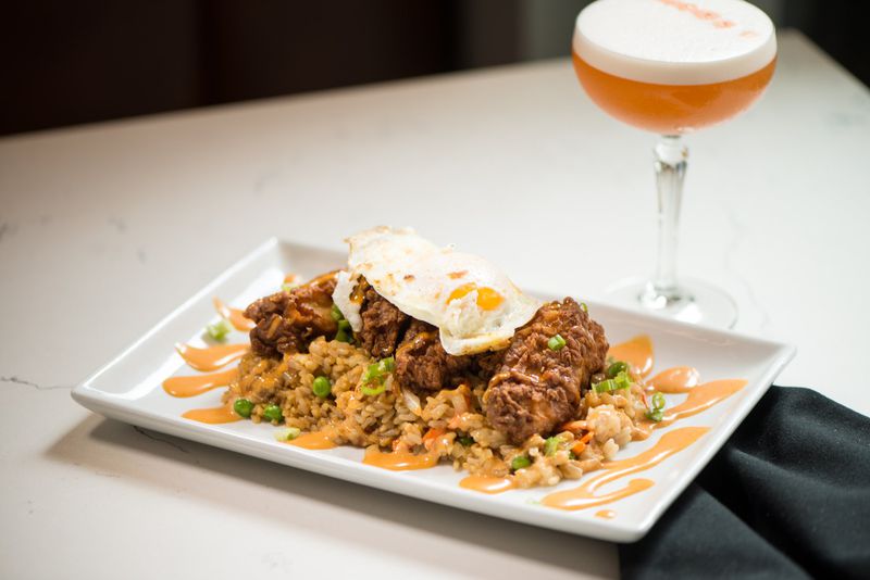Crispy Chicken and Fried Rice with ginger, lime, onion, carrot, and an egg. Photo credit- Mia Yakel.