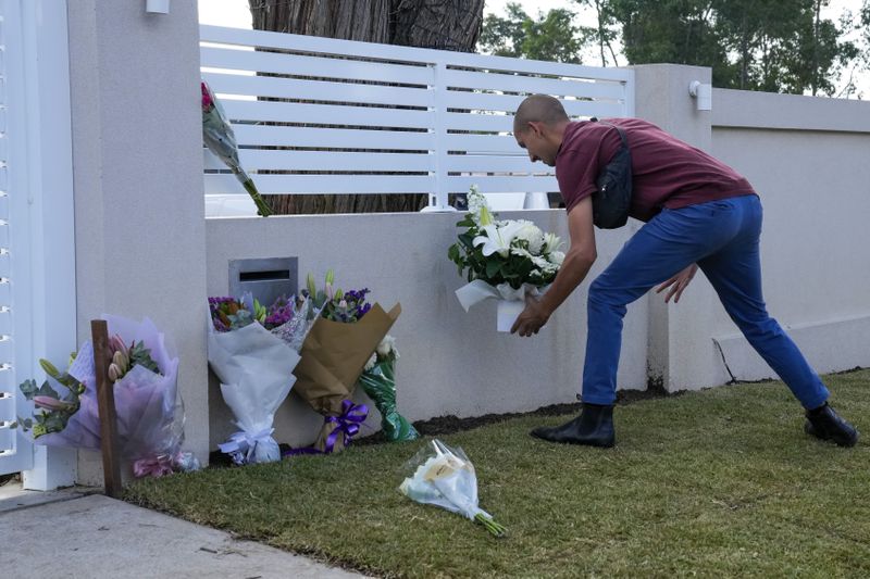 A man places flowers outside the Christ the Good Shepherd church in suburban Wakely in western Sydney, Australia, Tuesday, April 16, 2024. Australian police say a knife attack in Sydney that wounded a bishop and a priest during a church service as horrified worshippers watched online and in person, and sparked a riot was an act of terrorism. (AP Photo/Mark Baker)