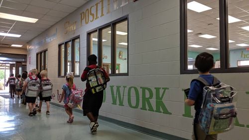 Students file out the front door at Worth County Primary School on May 9, 2019. They are too young for state standardized tests, which start in third grade. But the K-2 school in Sylvester, Ga., used federal grant money to purchase special reading tests to gauge their progress, and on this day, they had their final tests of the year. (The walls are covered with words to emphasize the focus on literacy.) Like all Georgia school districts, Worth County is now getting more federal dollars — an additional $1.1 million — towards coronavirus-related costs.