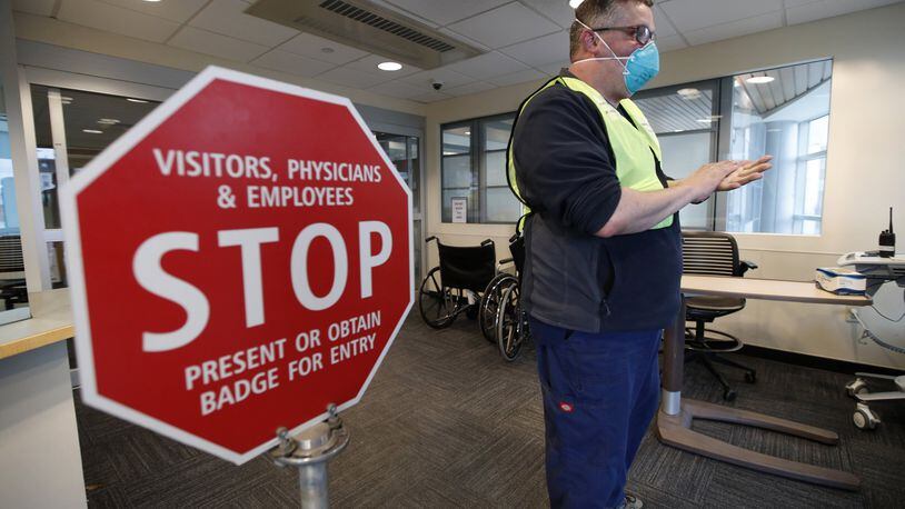 Bradley Mattes, associate nurse leader at Central Maine Medical Center, questions patients at the emergency entrance to the hospital in Lewiston, Maine, Friday, March 13, 2020. (AP Photo/Robert F. Bukaty)