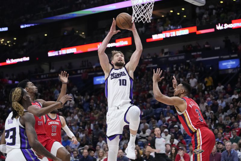 Sacramento Kings forward Domantas Sabonis (10) goes to the basket over New Orleans Pelicans guard CJ McCollum (3) in the first half of an NBA basketball play-in tournament game in New Orleans, Friday, April 19, 2024. (AP Photo/Gerald Herbert)
