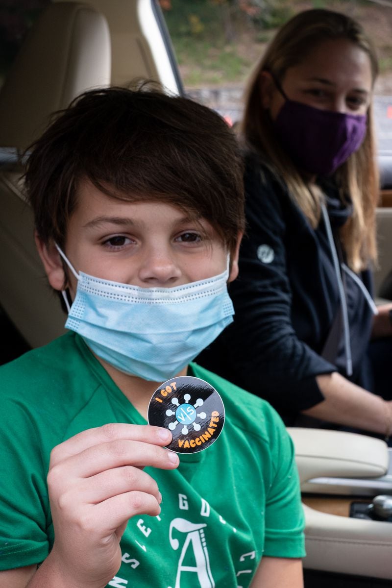 Teddy Lucas, 10, shows off his vaccinated sticker just after receiving his first COVID-19 vaccine shot Wednesday. Ben Gray for the Atlanta Journal-Constitution