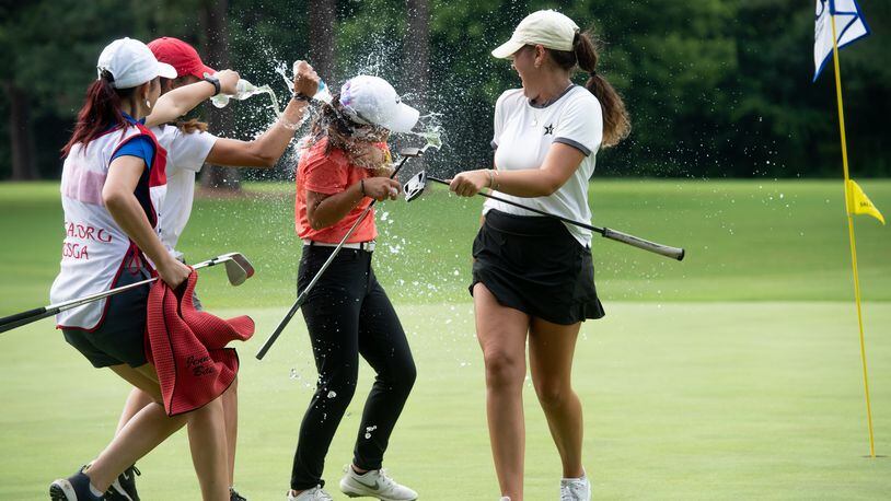 Jenny Bae is doused with water after winning the 92nd Georgia Women's Amateur Championship at Coosa Country Club in Rome. (L-R) Caddie and longtime friend Amy Ng, UGA teammates Alison Crenshaw drench Bae, while Buford's Tess Davenport, who finished second, tries to avoid the water.