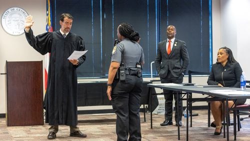 Judge Robert McBurney (left) swears in a bailiff in the Jury Assembly Room at Fulton County Courthouse in Atlanta on Tuesday, July 11, 2023 as Fulton County District Attorney Fani Willis (right) looks on. Two Fulton County grand juries are being selected, one of which will be expected to decide whether to hand up an indictment in the long-running investigation into alleged meddling with the 2020 presidential election. (Arvin Temkar / arvin.temkar@ajc.com)