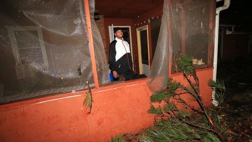 Mike Richardson, 47, checks on damage to his home after a radar-confirmed tornado downed six trees in his yard on John Rivers Road on Wednesday, Nov. 18, 2015, in Fairburn. Richardson said "it felt like the Wizard of Oz. The funnel was right outside the window. It was surreal. I can’t believe the windows didn’t blow.” Curtis Compton / ccompton@ajc.com