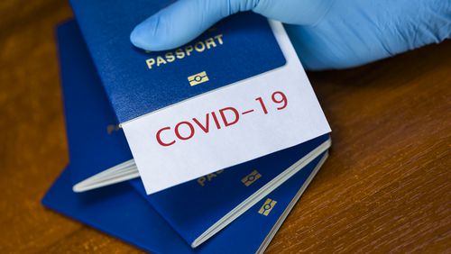 Man holding a passport with COVID-19 sign stamped onto a white paper. SITA has launched HealthProtect for airlines to share health information. Source: SITA