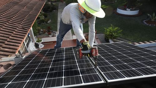 PALMETTO BAY, FL - Roger Garbey, from the Goldin Solar company, installs a solar panel system on the roof of a home a day after the Trump administration announced in January it will impose duties of as much as 30 percent on solar equipment made abroad. Daren Goldin the owner of the company said, ‘The tariffs will be disruptive to the American solar industry and the jobs they create.’ (Photo by Joe Raedle/Getty Images)