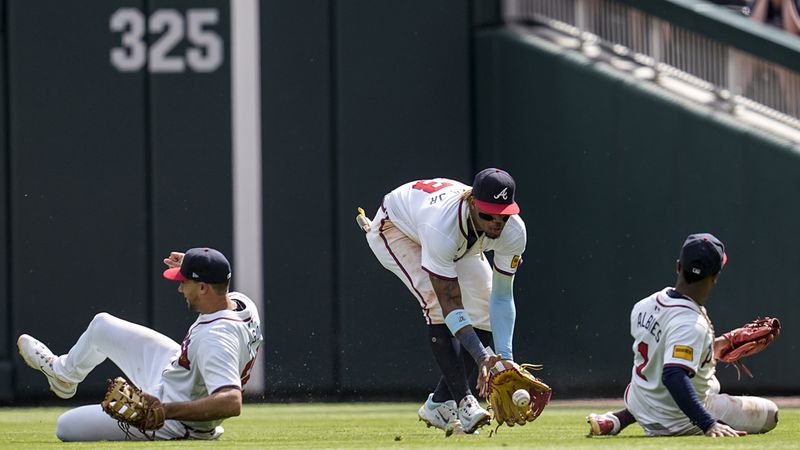 Atlanta Braves outfielder Ronald Acuña Jr. (middle) grabs a ball teammates Matt Olson (Left) and Ozzie Albies can't reach on April 28, 2024, in Atlanta. (AP Photo/Mike Stewart)