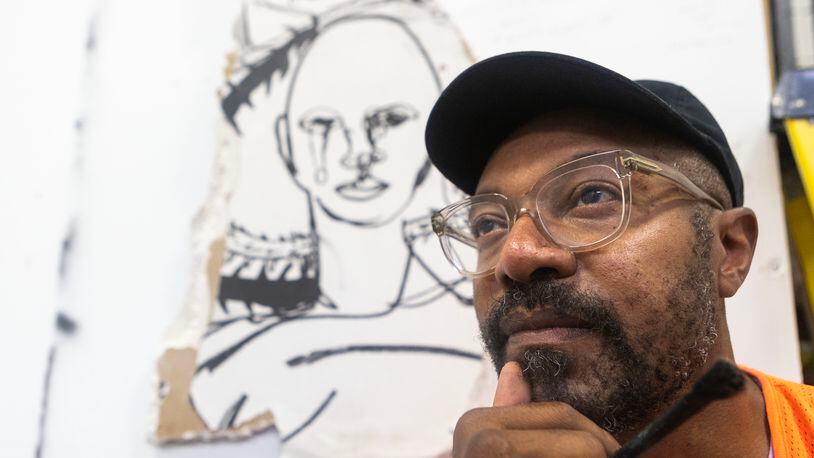 Atlanta painter William Downs poses for a portrait in front of his ‘living daymare' art piece on August 28, 2023 in Atlanta. (Michael Blackshire/Michael.blackshire@ajc.com)