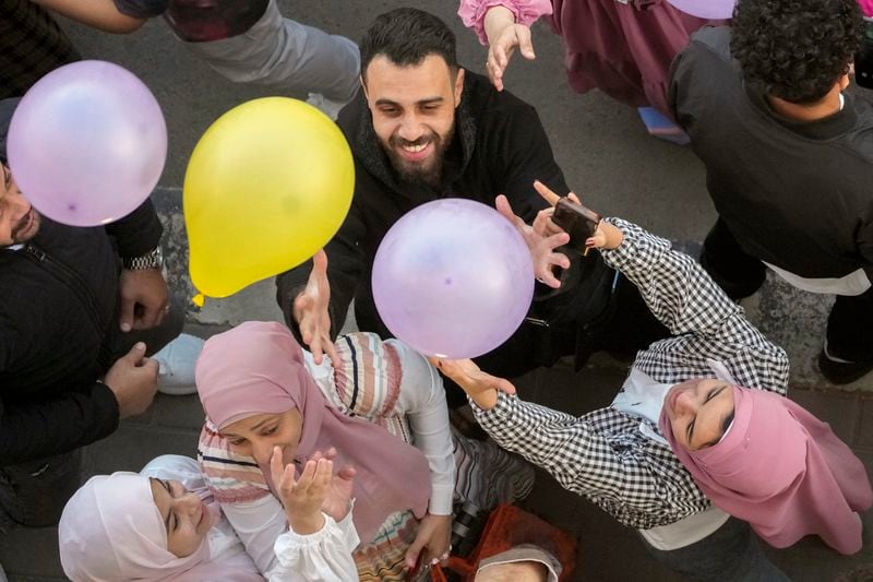 FILE - Muslims try to catch balloons distributed after Eid al-Fitr prayers, marking the end of the Muslim holy fasting month of Ramadan outside al-Seddik mosque in Cairo, Egypt, Friday, April 21, 2023. (AP Photo/Amr Nabil, File)