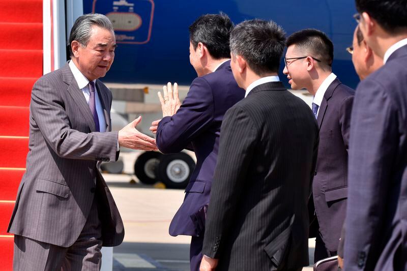 In this photo released by Agence Kampuchea Press (AKP), Chinese Foreign Minister Wang Yi, left. is greeted on his arrival at Phnom Penh International Airport in Phnom Penh, Cambodia, Sunday, April 21, 2024. (AKP via AP)
