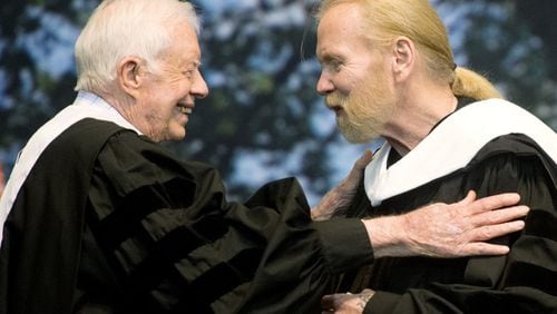 Former President Jimmy Carter and Rock and Roll Hall of Famer Gregg Allman embrace while Allman receives an honorary Doctor of Humanities degree during Mercer University’s commencement at Hawkins Arena in Macon, Ga., on Saturday, May 14, 2016. (Jason Vorhees/The Macon Telegraph via AP) MANDATORY CREDIT