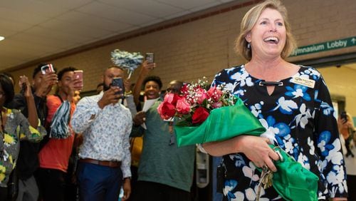 Collins Hill High School Principal Kerensa Wing walks into the lobby to a celebration by students and faculty on Monday, Oct. 21, 2019, in Suwanee. Wing was named 2020 National Principal of the Year by the National Association of Secondary School Principals. REBECCA WRIGHT FOR THE ATLANTA JOURNAL-CONSTITUTION