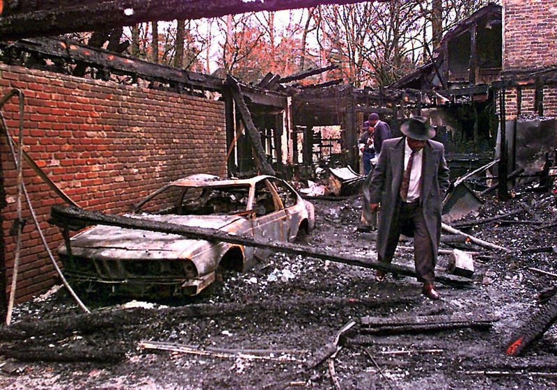 961211-12/11/96-ATLANTA- Atlanta Police detective Marshall Walker (right) look s over the charred remains of an arson fire at the home of businessman David Coffin. Atlanta police are investigating it as an apparent homicide and say that the man was burglarized over the weekend. A report from the medical examiner is pending for cause of death. (AJC Staff Photo/John Spink)