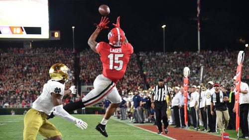 Georgia wide receiver Lawrence Cager (15) makes a touchdown pass over Notre Dame cornerback Troy Pride Jr. (5) in the second half  in a NCAA college football at Sanford Stadium in Athens on Saturday, September 21, 2019. Georgia defeated Notre Dame 23-17. (Hyosub Shin / Hyosub.Shin@ajc.com)
