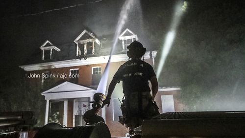 Firefighters continue to douse hot spots at the historic Furber Cottage building Thursday morning. It was used as a dorm first at Atlanta University and then at Morris Brown College before it was sold as part of bankruptcy proceedings in 2014.