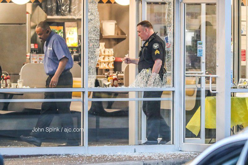 Glass is shattered near the seating area of the Waffle House in Atlanta where a masked man robbed the restaurant and patrons Tuesday morning.