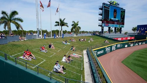 Baseball fans are spaced apart in left field as they watch of a spring training game between Minnesota Twins and Atlanta Braves, Friday, March 5, 2021, in North Port, Fla. (John Bazemore/AP)
