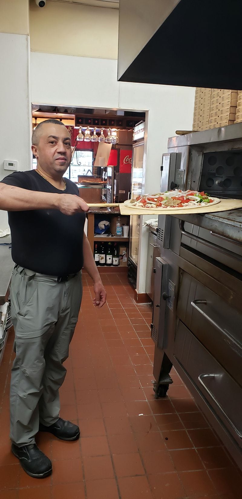 Naples native Biagio Schiano “Gino” Moriello shows off one of his New York-style pizzas at Taste of Italy. Courtesy of Biagio Schiano Moriello