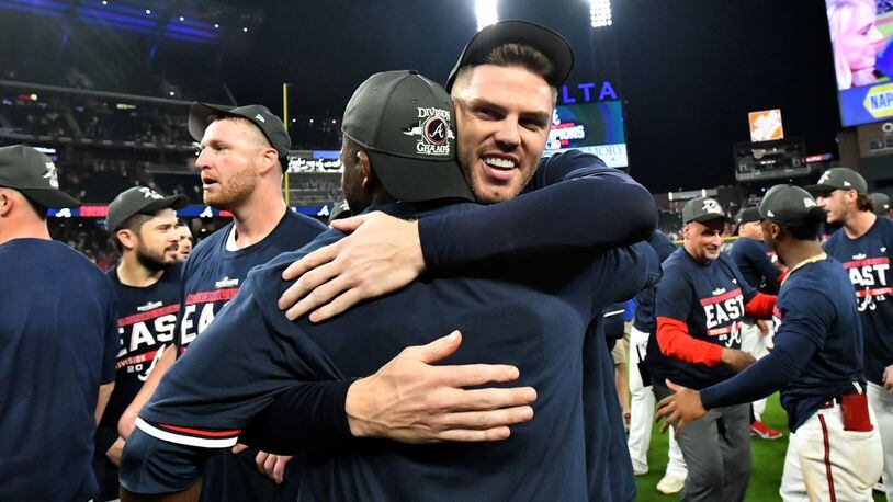 Braves first baseman Freddie Freeman hugs a teammate as the team celebrates on the field after clinching its fourth straight division title with 5-3 victory over the Philadelphia Phillies Thursday, Sept. 30, 2021, at Truist Park in Atlanta. (Hyosub Shin/hshin@ajc.com)