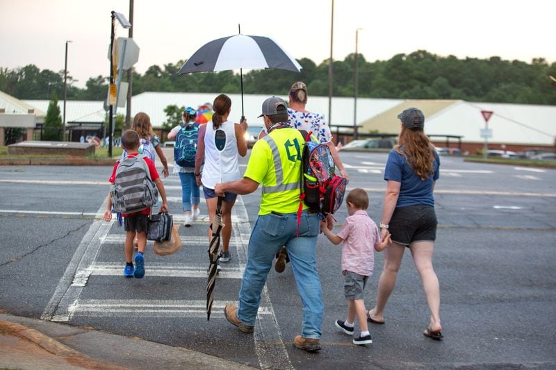 Parents walk their children to the entrance of Woodstock Elementary School on the first day of school on August 3, 2020.  STEVE SCHAEFER FOR THE ATLANTA JOURNAL-CONSTITUTION
