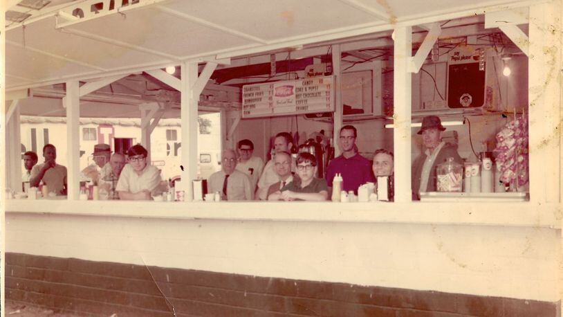 Writer Bill King (at left, leaning on counter), his brother Jonathan (center) and their dad, William D. King (far right), are seen in the Evening Optimist Club fair booth in the late 1960s. (Courtesy of the King family)