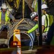 Crews are seen lowering a large pipe during repairs to a broken water main at West Peachtree Street in Midtown Tuesday morning, as the water crisis reached its fifth day. June 4, 2024.