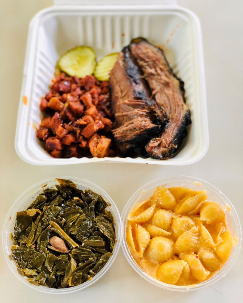This takeout from Heirloom Market BBQ includes spicy Korean pork and brisket, with collards and mac and cheese. CONTRIBUTED BY WENDELL BROCK