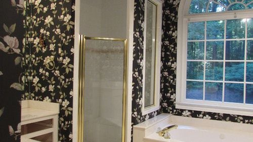 Magnolia wallpaper dated and darkened the bathroom of a Milton home before a renovation. PHOTO CREDIT: Beth Johnson