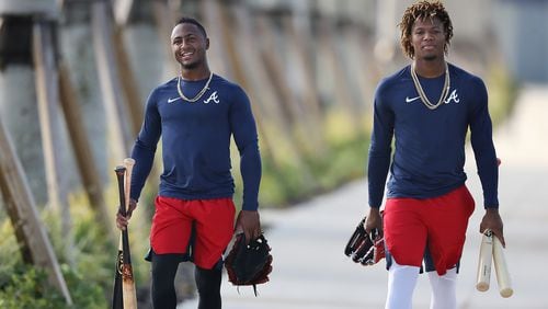 With bats and gloves in hand, Braves second baseman Ozzie Albies and outfielder Ronald Acuna head to the batting cages for some practice Thursday, Feb. 13, 2020, in North Port, Fla.