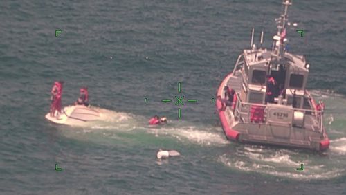 In this photo released by the U.S. Coast Guard, members of the Coast Guard rescue a family of four Wednesday from a vessel taking on water 17 miles south of Southwest Pass near Venice, Louisiana.