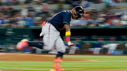 The Braves' Ronald Acuna Jr. gestures to the dugout after hitting a solo home run against the Texas Rangers during the sixth inning of a baseball game Wednesday, May 17, 2023, in Arlington, Texas. (AP Photo/Tony Gutierrez)
